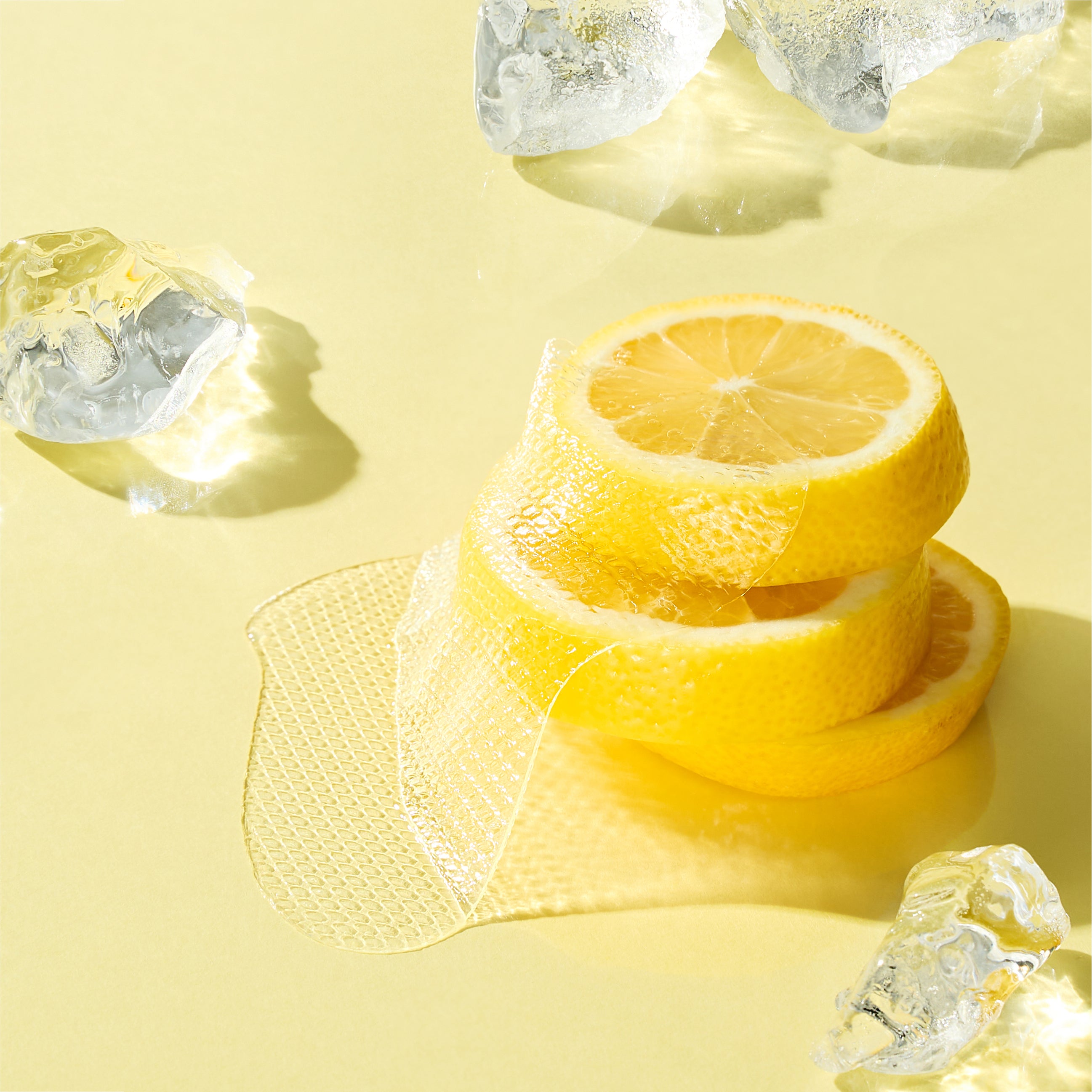 Stack of lemon slices with ice cubes on a yellow background
