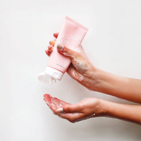 Lathered hands holding the Rise + Shine Cleanser Tube